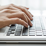 Hands typing on a keyboard