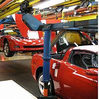 Cars on a conveyor system in a manufacturing plant.