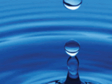 Water and Wastewater Systems Sector Drop of water after it has hit a body of water with droplets in the air and ripples flowing out from the epicenter.