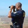 DHS agent using binoculars