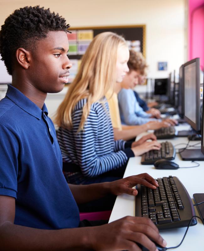 Teenager boy and classmates in high school computer class