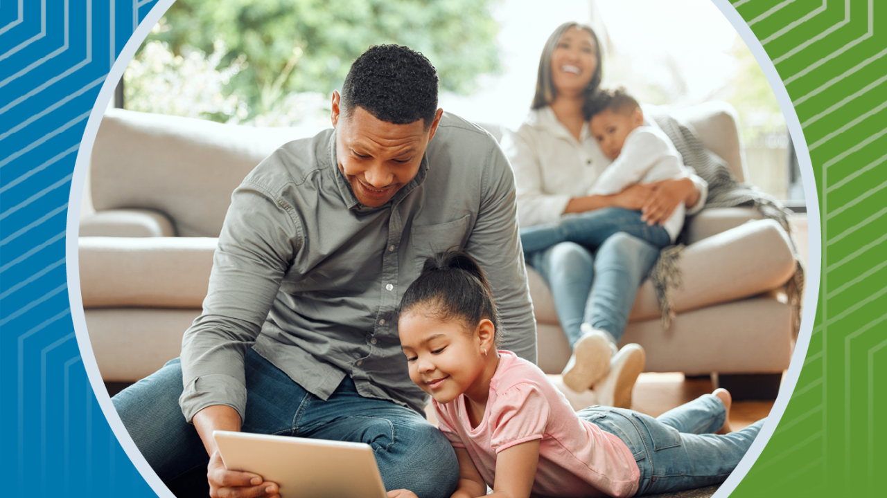 A family gathers in their living room watching a tablet together