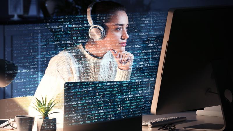 A female behind a computer screen doing cyber work