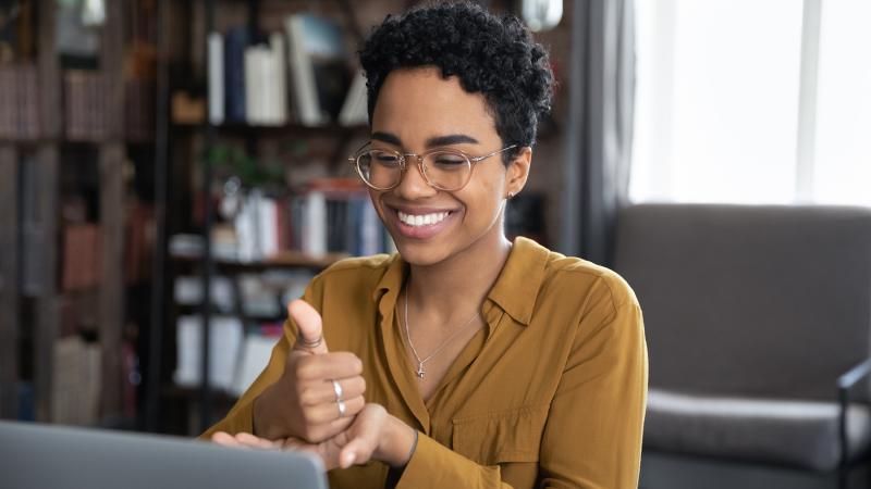 Person doing American Sign Language sitting at a computer