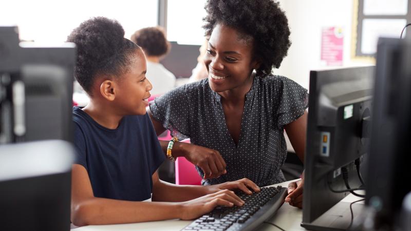 A teacher and student sitting at a desk