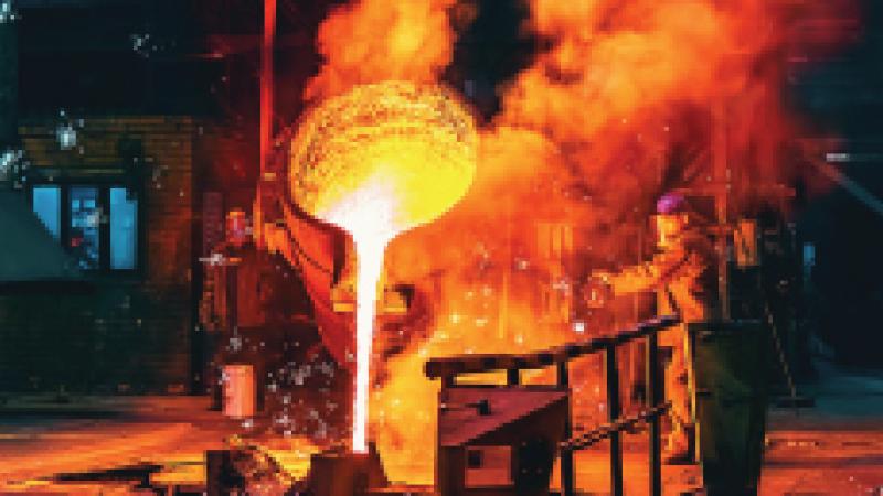 Image of molten metal being poured into containers by people wearing safety equipment