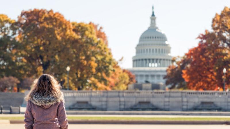 A woman standing in front of the capital building