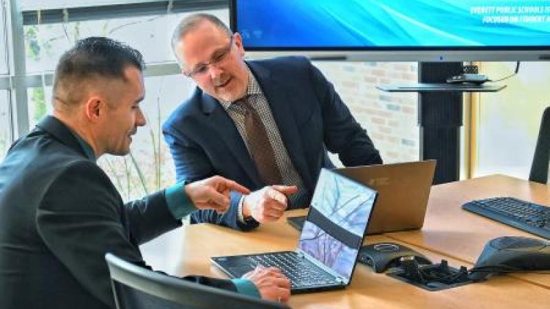 a photo of two men on computers