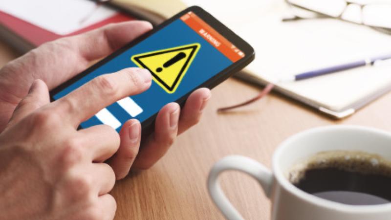 Person using a phone displaying an emergency symbol