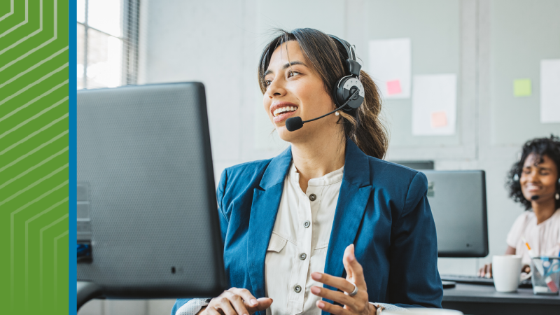 women at her desk working and speaking into a headset