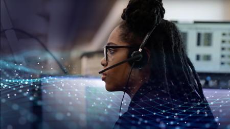 A public safety telecommunicator sitting at a dispatch station.