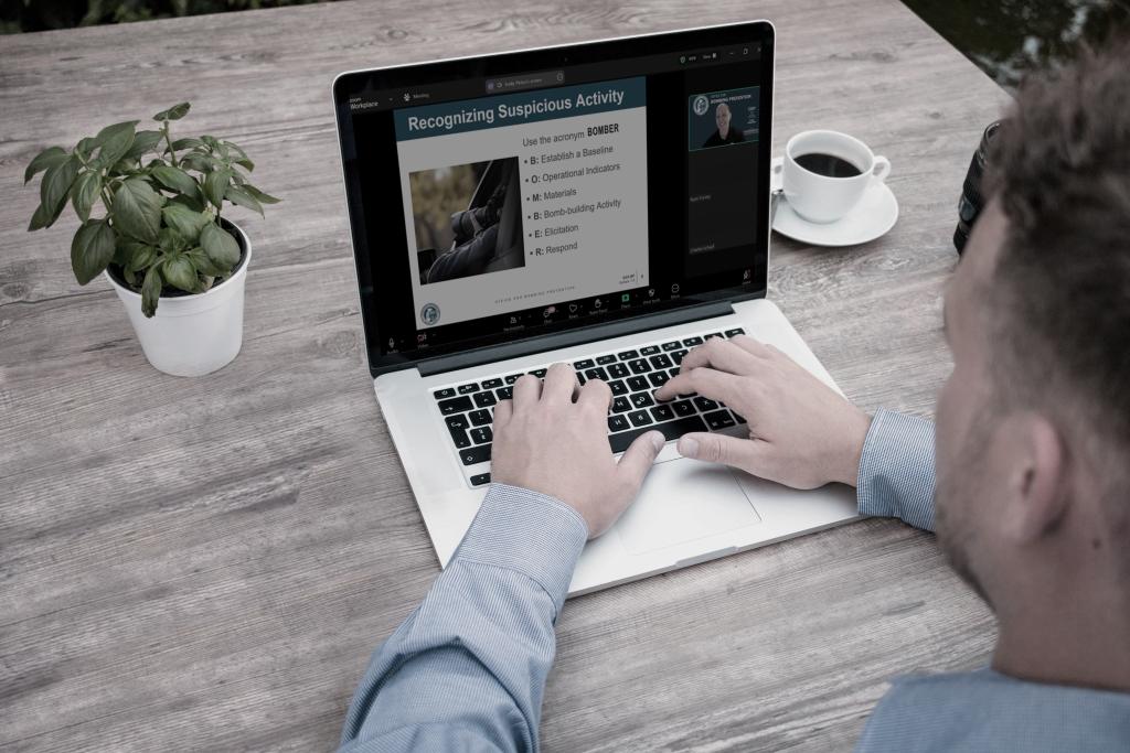 Individual sitting at a desck working on a laptop