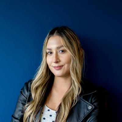 Woman standing against a blue wall