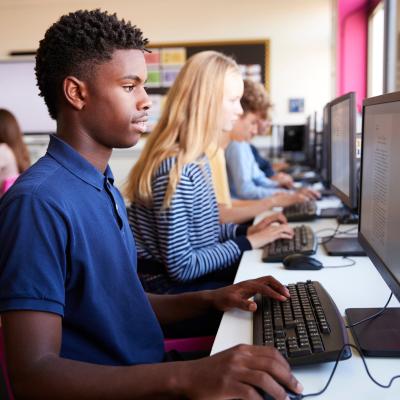Teenager boy and classmates in high school computer class
