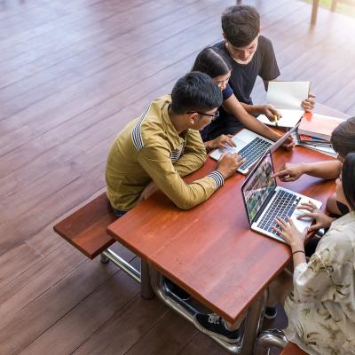 Kids sitting around a desk at school