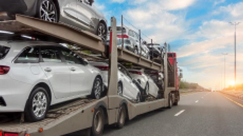 Transportation of new and very expensive cars. Hauling cars trailer and truck pulls rides on the highway.